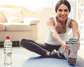 Ženy provádí žilní gymnastiku na jógové podložce jako prevenci těžkých nohou.